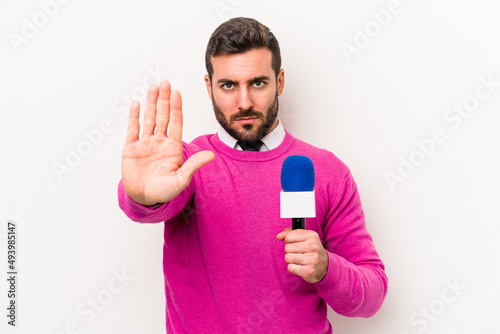 Young caucasian tv presenter man isolated on white background standing with outstretched hand showing stop sign, preventing you.