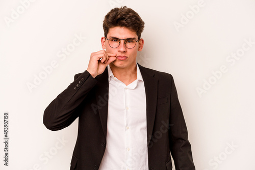 Young caucasian business man isolated on white background with fingers on lips keeping a secret.