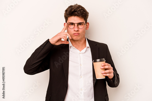 Young caucasian business man holding takeaway coffee isolated on white background pointing temple with finger, thinking, focused on a task.