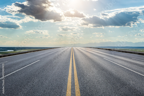 Straight asphalt road and beautiful sky clouds at sunrise