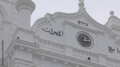 Galle Fort - Meeran Jumma Masjid. Sri Lanka. Clock on the mosque close-up. Snow-white beautiful mosque building in Galle Fort. Slow motion120 fps video, ProRes 422, 10 bit, ungraded C-LOG photo