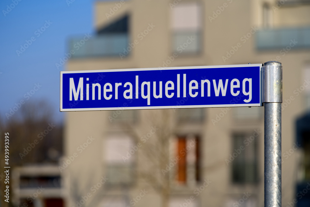 Obraz premium Street sign with word Mineralquellenweg (German, translation ist way of mineral spring) on a sunny spring day. Canton Zürich. Photo taken March 7th, 2022, Zurich, Switzerland.