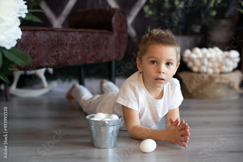 Sweet toddler child, cute boy playing with Easter eggs, Easter decoration
