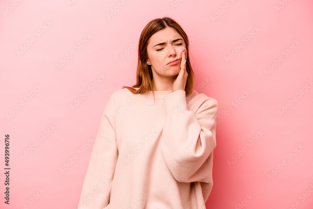 Young caucasian woman isolated on pink background having a strong teeth pain, molar ache.