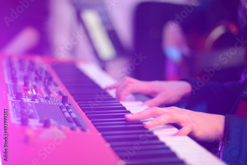 Closeup of  Musician 's hands playing synthesizer at a live show on stage photo