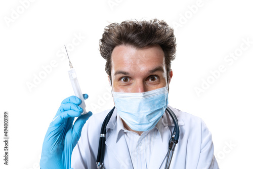 Ready for injection. Male young doctor with stethoscope and face mask on white studio background. Looks sad, serious. Concept of healthcare and medicine, war, help, treatment