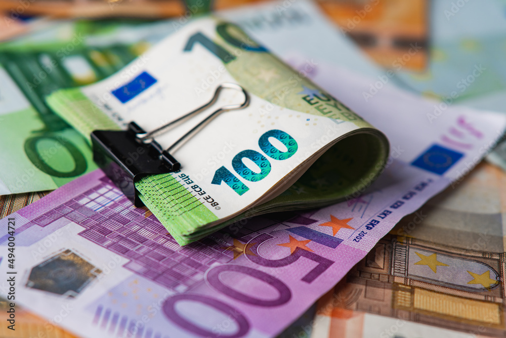 Euro in stationery clip on pile paper banknotes five one hundred and fifty euro. Heap of money Euro in stationery clip on pile paper banknotes five one hundred and fifty euro. Heap of money