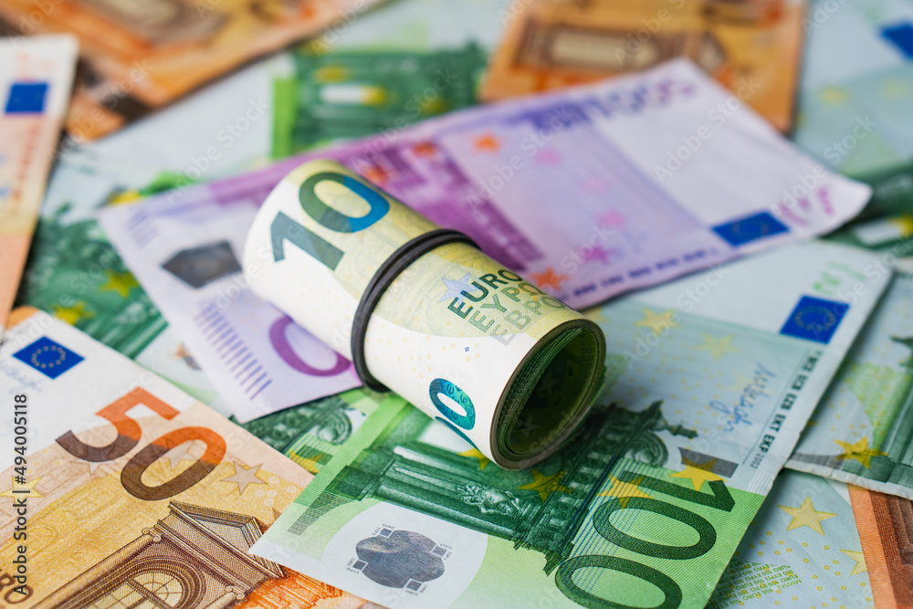 Obraz premium Euro in stationery band on pile of paper banknotes five one hundred and fifty euro. Heap of money
