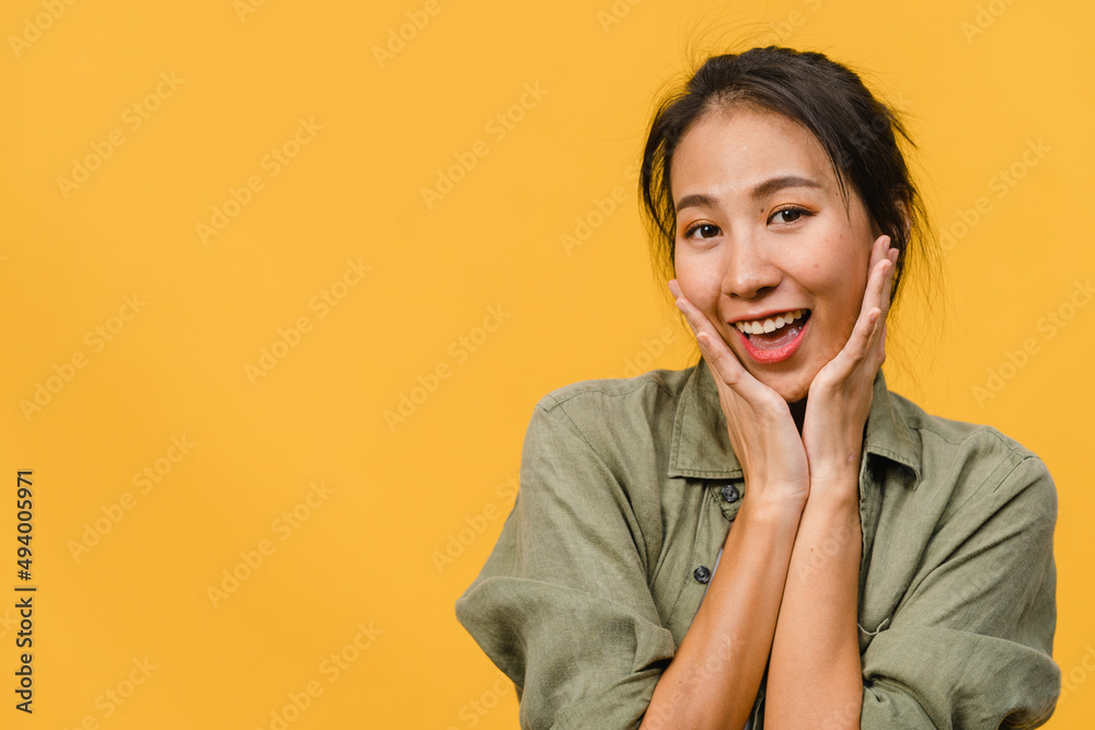 Young Asia lady with positive expression, smile broadly, dressed in casual clothing and looking at camera over yellow background. Happy adorable glad woman rejoices success. Facial expression concept. Young Asia lady with positive expression, smile broadly, dressed in casual clothing and looking at camera over yellow background. Happy adorable glad woman rejoices success. Facial expression concept.