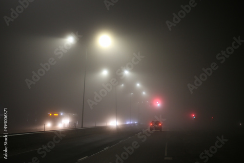 Misty city view of highway with traffic and car lights.