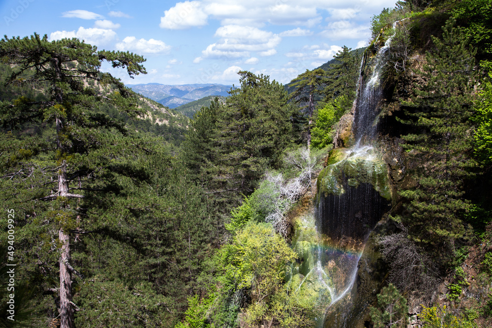 Obraz premium Blue sky with view of small waterfall in forest