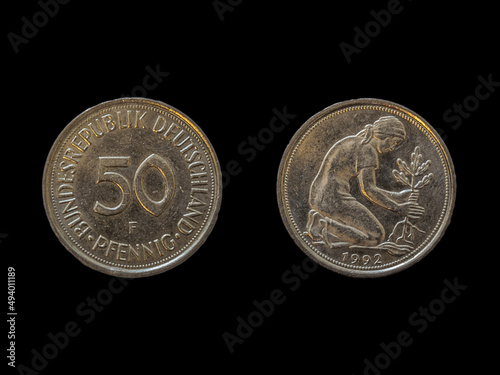 Top view of the front and back of a historic West Germany pfennig coin on a black background