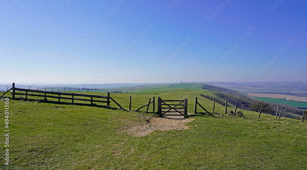 Walking to Firle Beacon, green hills and fence, South Downs 