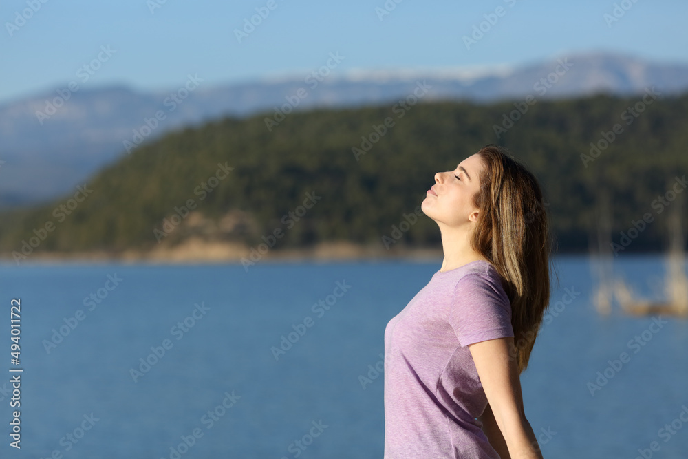 Satisfied teenage female breathing fresh air in a lake Satisfied teenage female breathing fresh air in a lake