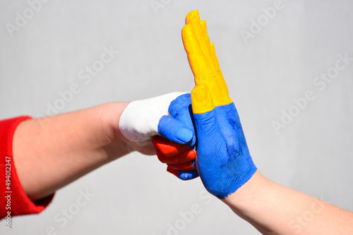 Conflict between Russia and Ukraine, symbol of Ukrainian power and protest. Hands in colors of flags Russia and Ukraine ,stop war in Ukaine ,stand with Ukraine