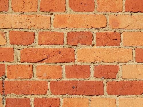 Mur cimenté en briques anciennes incluant plusieurs nuances de rouges-oranges