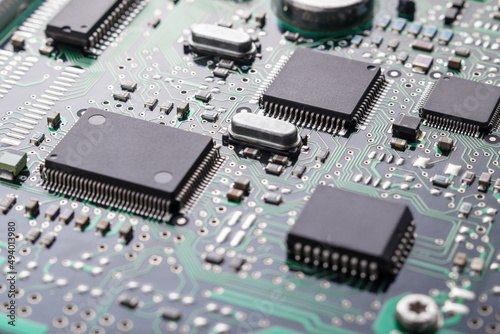 High tech technology background with printed circuit board PCB, chips and many electronic components, selective focus.
