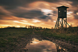 Hunting tower, raised hide in the sunset with clouds