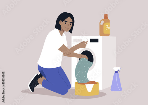A young female Caucasian character loading a washing machine with a pile of laundry, domestic chores
