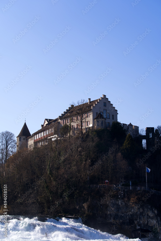 Laufen Castle on a hill above the famous Rhine Falls on a sunny spring day. Photo taken March 5th, 2022, Laufen-Uhwiesen, Switzerland.