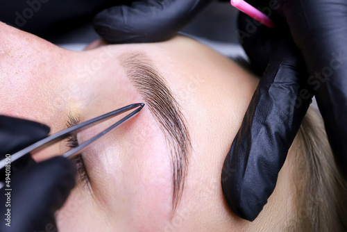 removal of hairs in the eyebrows with tweezers after dyeing and laminating hair