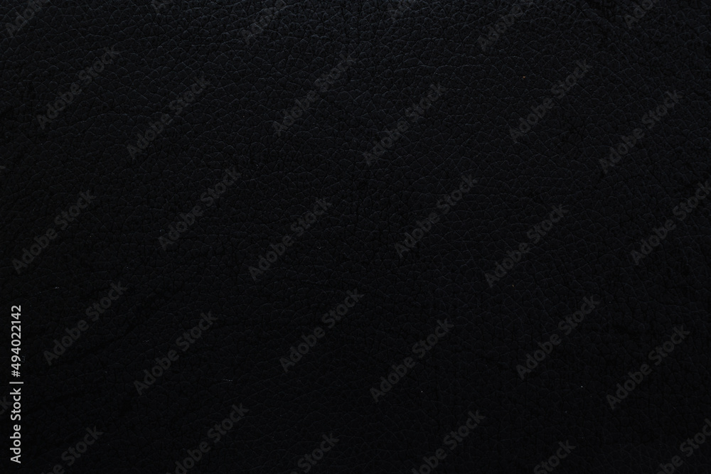 black faux leather background is used to wrap book covers or to repair everyday leather sofa seats and appliances. background and pattern on the black faux leather have space for text.