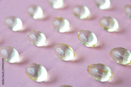 Close up photo of omega 3 fish oil capsules on pink background
