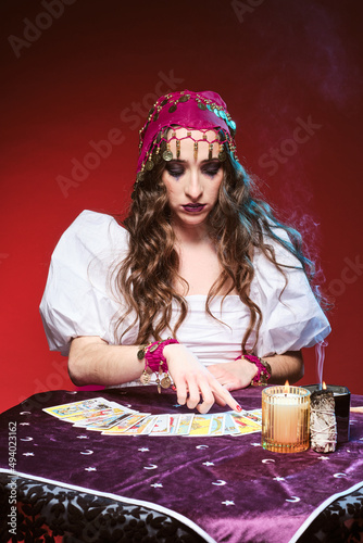 Female fortune teller pointing to tarot cards