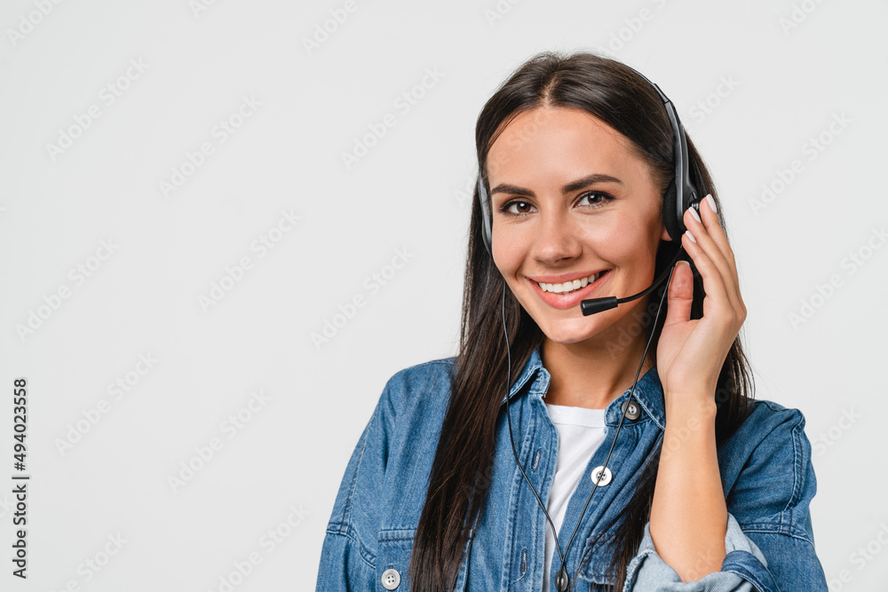 Closeup cropped of young friendly caucasian woman IT support customer support agent hotline helpline worker in headset looking at camera while assisting customer client isolated in white background Closeup cropped of young friendly caucasian woman IT support customer support agent hotline helpline worker in headset looking at camera while assisting customer client isolated in white background