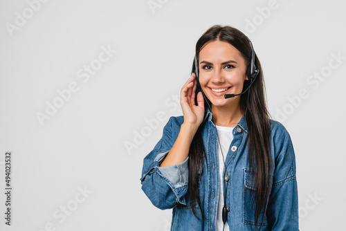 Young friendly caucasian woman IT support customer support agent hotline helpline worker in headset looking at camera while assisting customer client isolated in white background photo