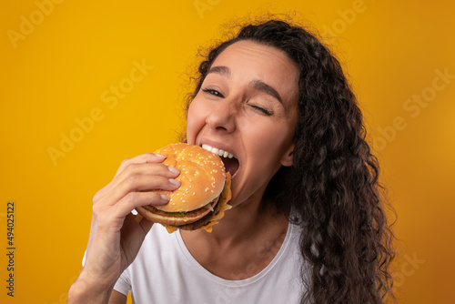 Hungry Latin Lady Holding Burger Biting Sandwich At Studio