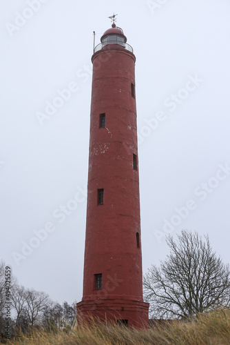 Old red lighthouse near Baltic sea in Latvia  called Akmensraga lighthouse.