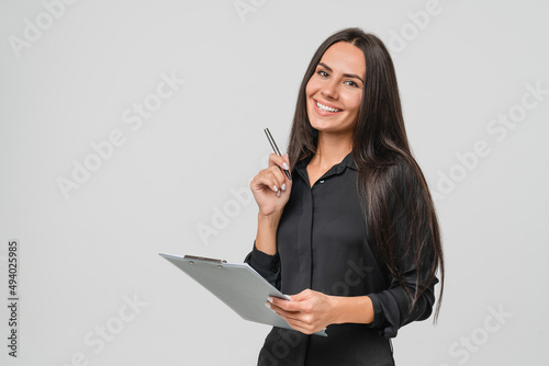 Smiling confident caucasian young businesswoman auditor writing on clipboard, signing contract document isolated in white background photo