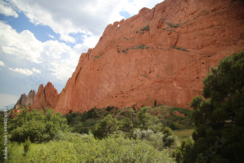 Giant red rock mountain with trees at the bottom in the Garden of the Gods - Colorado, USA
