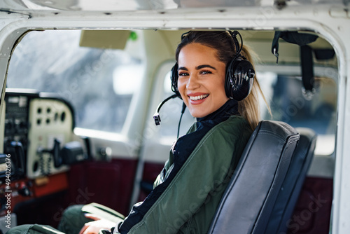 Print op canvas Portrait of smiling caucasian woman aviator, talking to the people at the radio station