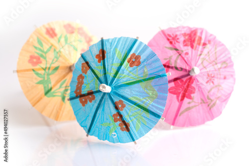 Paper colorful umbrella toothpicks decorate for cocktail glass isolated on white background  spring and summer welcome drink in hotel.