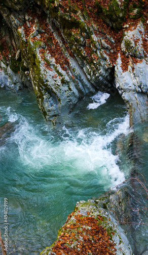 small waterfall on a river with blue clean water in a wild forest