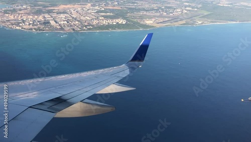 Plane flies over the ocean. 
