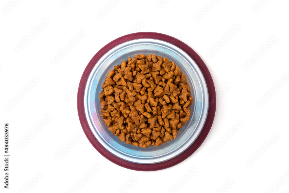 Dry food for cats and dogs in a red bowl on a white background, top view Dry food for cats and dogs in a red bowl on a white background, top view