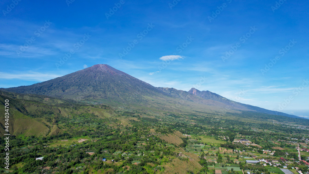 Fototapeta premium Aerial view of some agricultural fields in Sembalun. Sembalun is situated on the slope of mount Rinjani and is surrounded by beautiful green mountains. Lombok, Indonesia, March 22, 2022