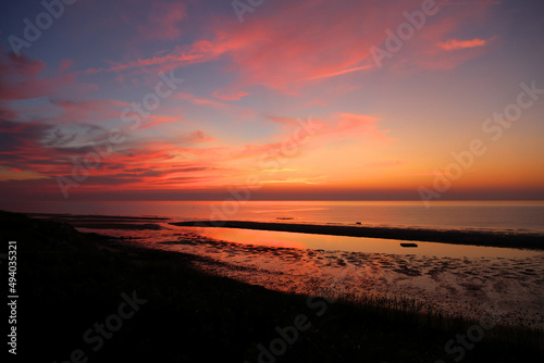 Fototapeta Naklejka Na Ścianę i Meble -  Bright orange sunset over Cape Cod Bay at the end of day