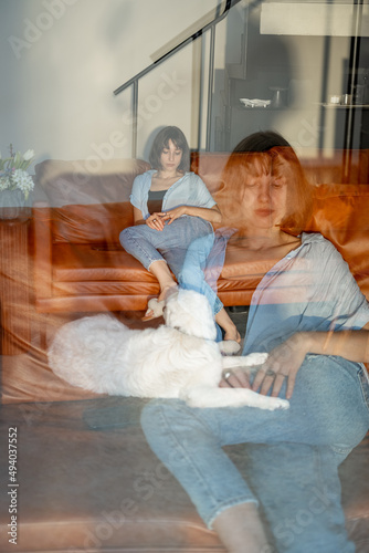 Portrait of a young confident woman sitting on couch at home. Double exposure image technic