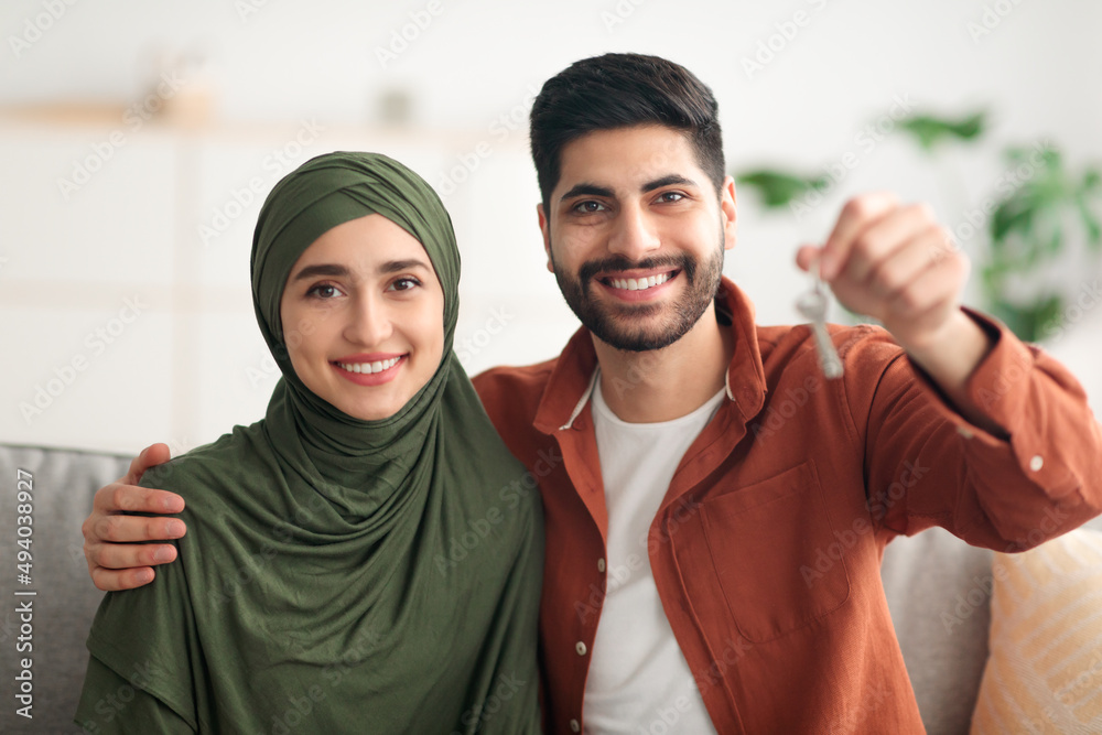 Happy Middle Eastern Couple Showing New House Key Indoor