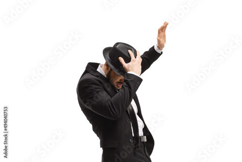 Obraz na plátně Man in a suit holding his hat