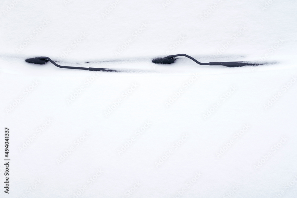 Cropped car with wipers covered with fresh snow in winter season. Selective focus. Stuck in snow. Copy space for text Cropped car with wipers covered with fresh snow in winter season. Selective focus. Stuck in snow. Copy space for text