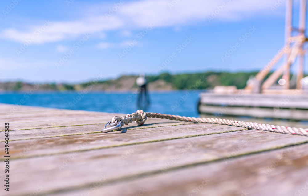 mooring's fastening for a boat floating facility on a wooden pier, a symbol of summer adventures, summer sketch in yellow and blue with a blurred seascape on the background mooring's fastening for a boat floating facility on a wooden pier, a symbol of summer adventures, summer sketch in yellow and blue with a blurred seascape on the background