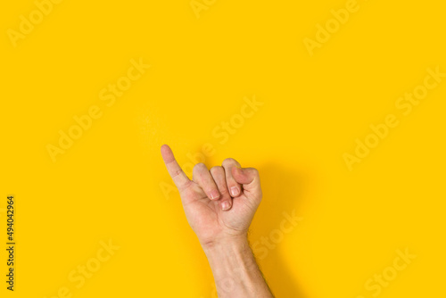 Mano con dedo meñique levantado, suerte sobre fondo amarillo brillante liso y aislado. Vista de frente y de cerca. Copy space