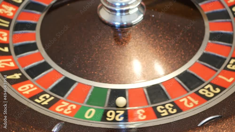 Ball on wooden french roulette table in casino. Wheel spinning, turning or rotating. Odd and even numbers, black, red and zero sectors. Bets in game of chance. Money playing, gambling or risky betting Ball on wooden french roulette table in casino. Wheel spinning, turning or rotating. Odd and even numbers, black, red and zero sectors. Bets in game of chance. Money playing, gambling or risky betting