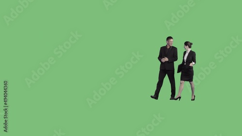 A business man and a woman in black suits go and talking. Perspective view