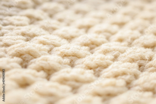 closeup beige knitted woolen fabric texture background